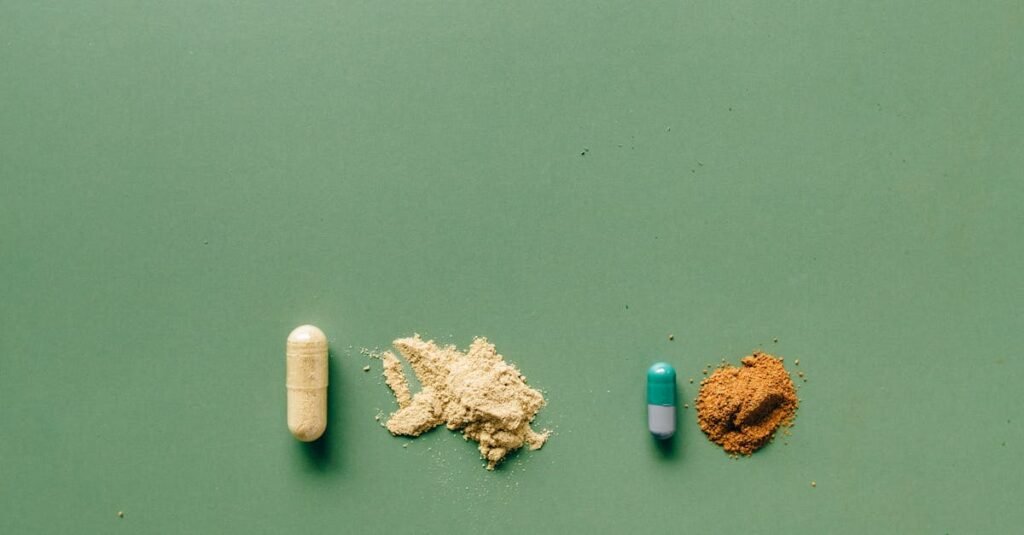 Une capsule jaune, shilajit, shilajit pur, un petit tas de poudre beige, shilajit en bocal, une capsule verte et blanche, shilajit resine, et un petit tas de poudre brune sont disposés en ligne sur une surface verte.