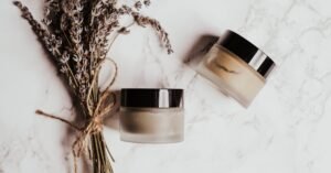 Deux pots en verre de shilajit pur et de shilajit en bocal avec couvercles noirs sur marbre, près de lavande séchée et de shilajit resine.